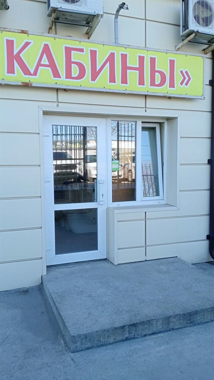 Входная дверь под вывеской «Ванны и кабины»